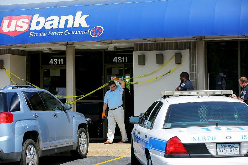 North Little Rock police detectives investigate a robbery Wednesday morning at the U.S. Bank branch at 4311 E. Broadway. 
