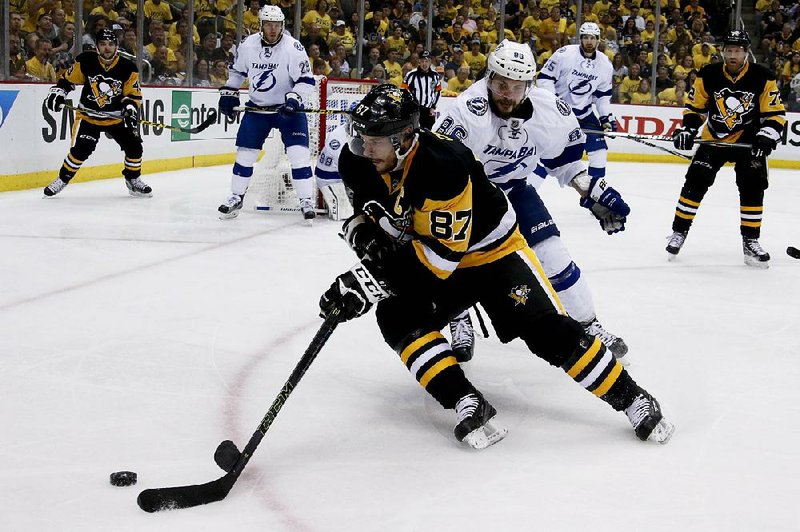 Sidney Crosby (87) of the Pittsburgh Penguins controls the puck in front of Nikita Kucherov in Game 7 of the NHL Eastern Conference fi nal Thursday night.