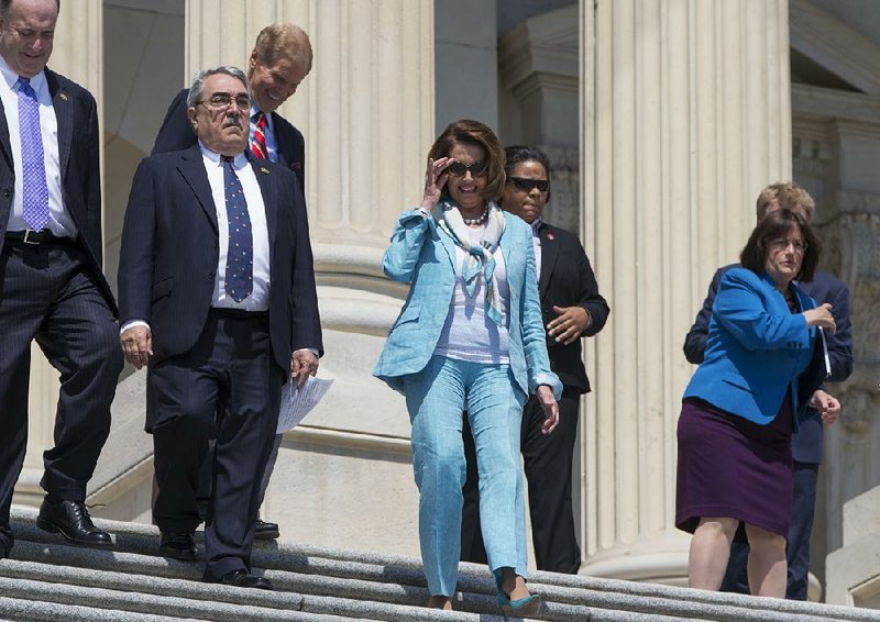 House Minority Leader Nancy Pelosi, (center) with Rep. G.K. Butterfield, D-N.C. (left), are joined by Democratic lawmakers as they head to a news conference Thursday on Capitol Hill. 