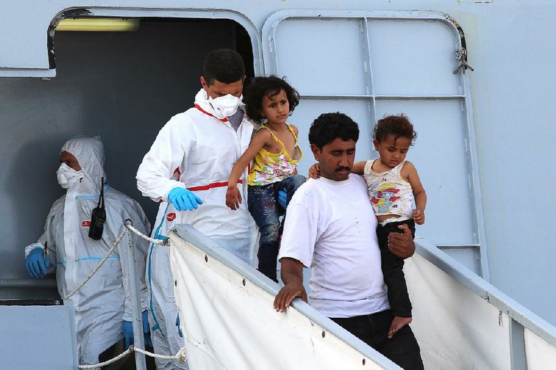 Migrants rescued after a smuggler’s boat capsized disembark Thursday from the Italian ship Bettica at Porto Empedocle in Sicily. 