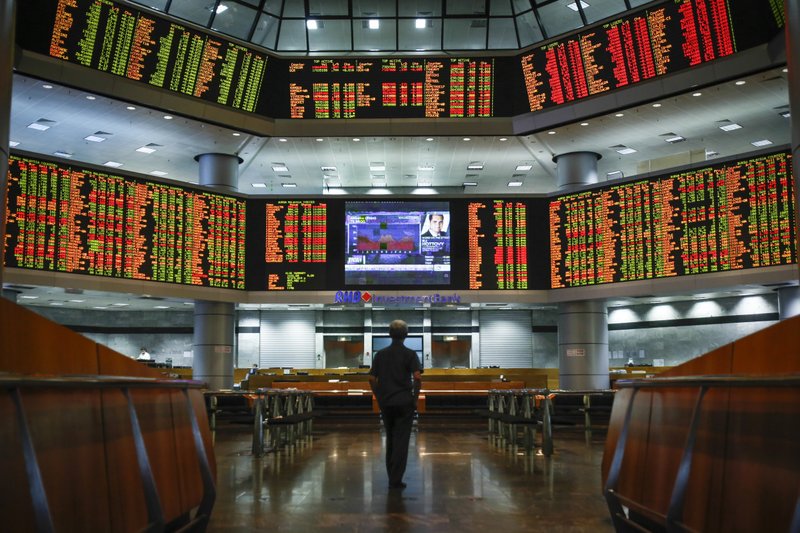 A Malaysian man watches trading boards at a private stock market gallery in Kuala Lumpur, Malaysia, Thursday, May 26, 2016. 