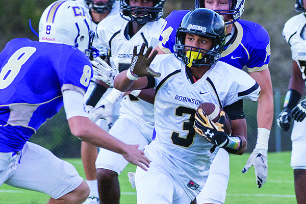 Pulaski Robinson receiver Nathan Page prepares to stiff arm Central Arkansas Christian defender Justin Flanigan during a game Friday, Sept. 11, 2015, at Mustang Mountain in North Little Rock.  