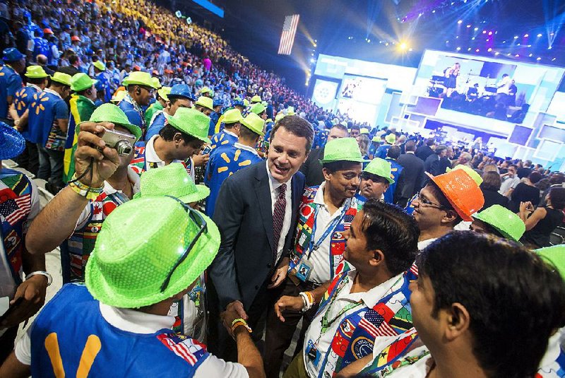 Doug McMillon, chief executive officer, stops to talk with employees from India at the company’s 2015 shareholder meeting. This year’s meeting will take place Friday.