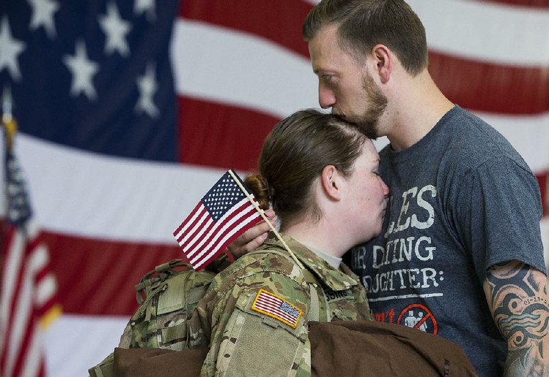 Spc. Katie Tippin and her husband, Michael, say goodbye Friday as members of the Army National Guard’s 77th Combat Aviation Brigade head from North Little Rock to Fort Hood, Texas, for deployment training. It’s Tippin’s first deployment.