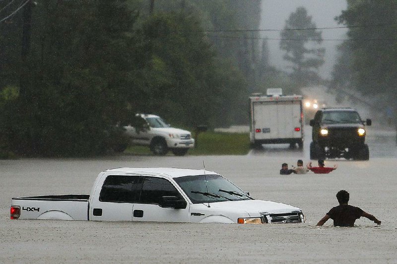 A truck sits in high water Friday in Magnolia, Texas, after the driver went around a barrier. Everyone got out safely. 