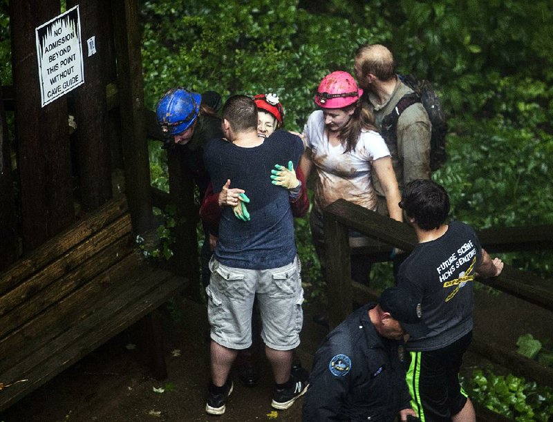 Tour guide Peggy Nims hugs a friend, after she made it out of Hidden River Cave, where more than a dozen people who were exploring the cave were trapped by rising water Thursday in Horse Cave, Ky. 