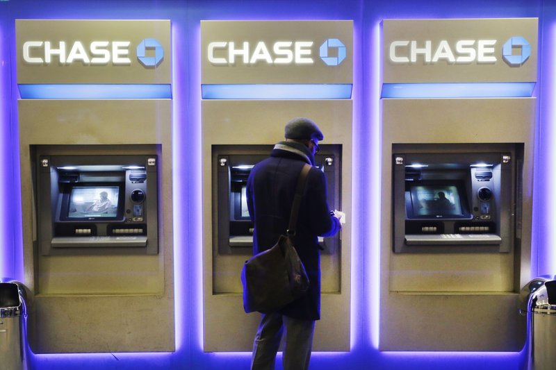 In this Wednesday, Jan. 14, 2015, file photo, a customer uses an ATM at a branch of Chase Bank, in New York.