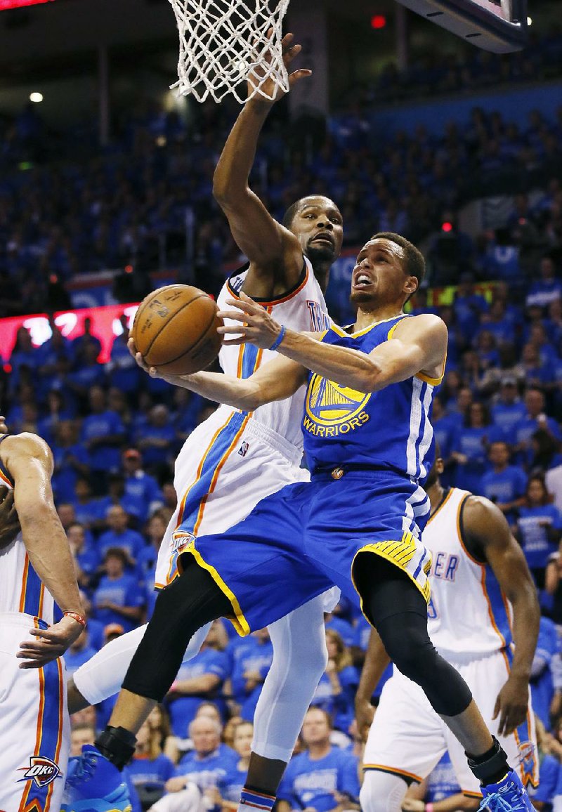 Oklahoma City defender Kevin Durant (left) tries to block a shot by Golden State guard Stephen Curry during Game 6 of the NBA Western Conference fi nal Saturday. Curry scored 22 of his 31 points in the second half to help the Warriors to a 108-101 victory, forcing a Game 7 on Monday night.