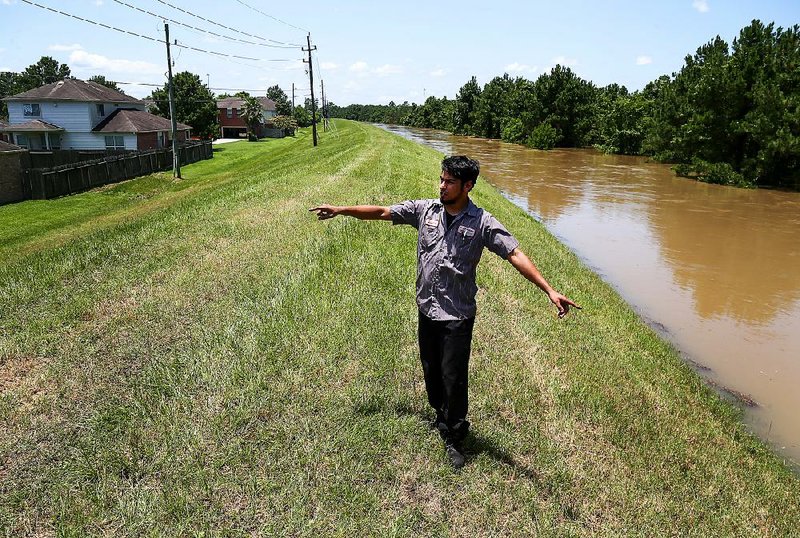 Leo Hernandez talks Saturday in Spring, Texas, north of Houston, about how high the water in Spring Creek rose after last week’s torrential rains.  