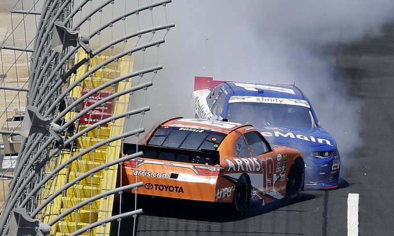 Daniel Suarez (19) spins in front of Elliott Sadler as they exit Turn 4 during the NASCAR Xfinity Series auto race at the Charlotte Motor Speedway in Concord, N.C., Saturday, May 28, 2016. 
