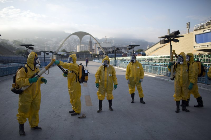 In this Tuesday, Jan. 26, 2016 file photo, health workers get ready to spray insecticide to combat the Aedes aegypti mosquitoes that transmits the Zika virus, under the bleachers of the Sambadrome in Rio de Janeiro, which will be used for the Archery competition in the 2016 summer games. 