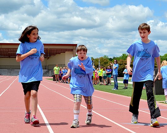 Submitted photo Lake Hamilton Intermediate School students Keely Hayes, left, and Brandon Tackett, right, cheer on Jaden Falgout during the annual track and field day.