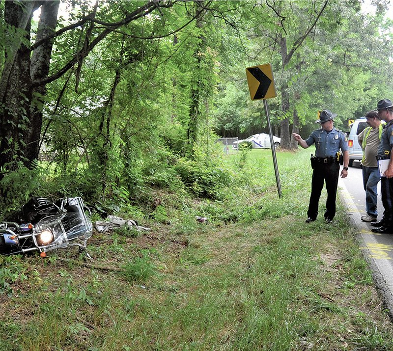 The Sentinel-Record/Mara Kuhn FATALITY WRECK: Emergency personnel work the scene of a fatal wreck involving an antique motorcycle Saturday afternoon at 2229 Mountain Pine Road. The male driver, who was southbound, lost control on a curve and left the roadway, Arkansas State Police Cpl. Brandon Cook said. The driver was pronounced dead at the scene by Garland County Deputy Coroner Ryan Hamilton. The accident occurred shortly before 2:30 p.m.