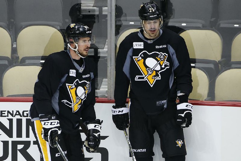 Pittsburgh’s Sidney Crosby (left) and Evgeni Malkin prepare to run a drill during practice Sunday in preparation for today’s Game 1 of the Stanley Cup Final against San Jose. The Penguins are looking to win their first title since 2009.