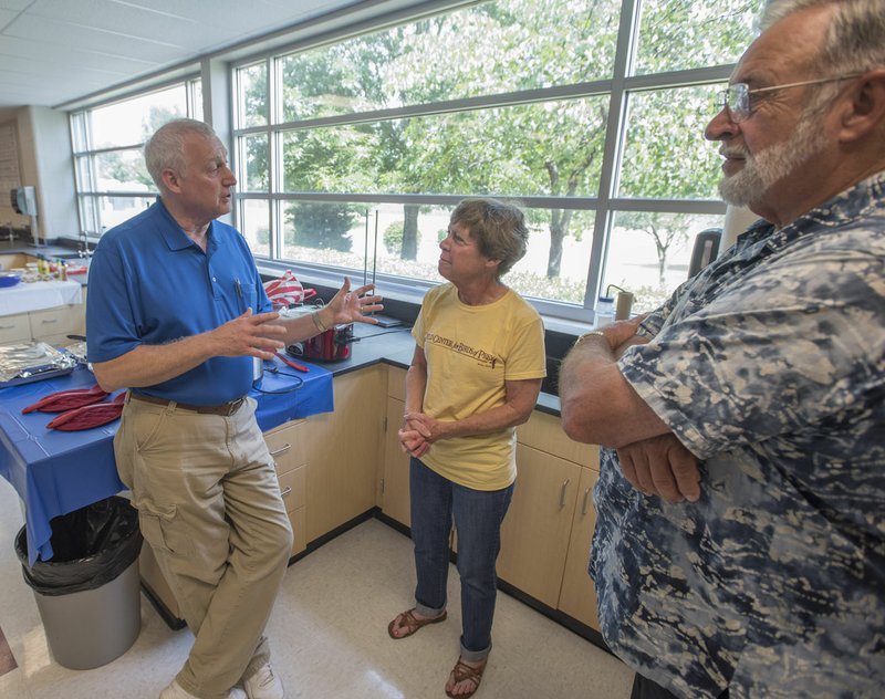 Steve Long (from left), a Rogers High School teacher, visits Thursday with Lynn Sciumbato and Bob Ross, both retired teachers. Long is retiring after teaching science (mostly chemistry) for 41 years.