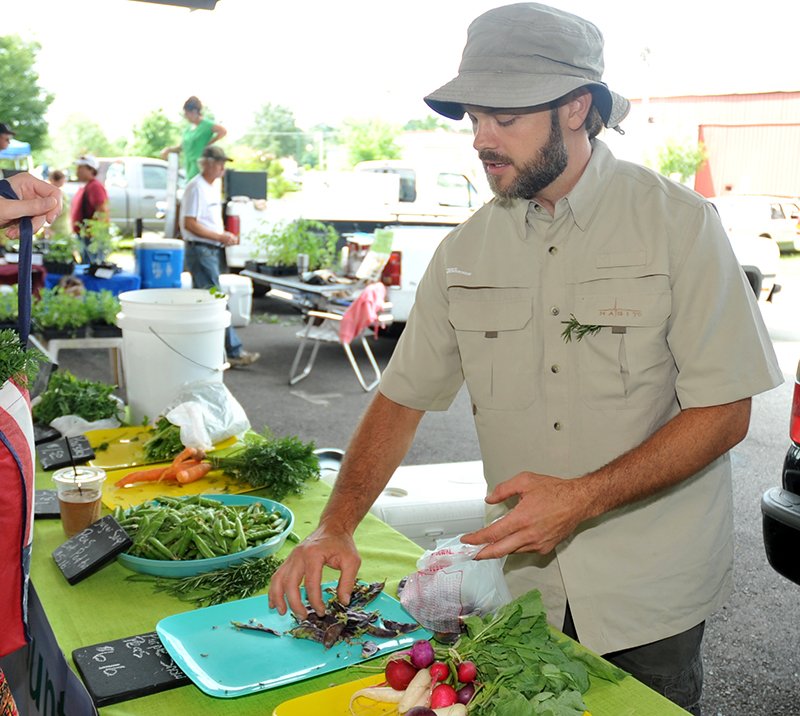 The Sentinel-Record/Mara Kuhn Brian Rogers with Ouachita Mountain Valley Farms of Joplin sells fresh produce Saturday at the Hot Springs Farmers &amp; Artisans Market.