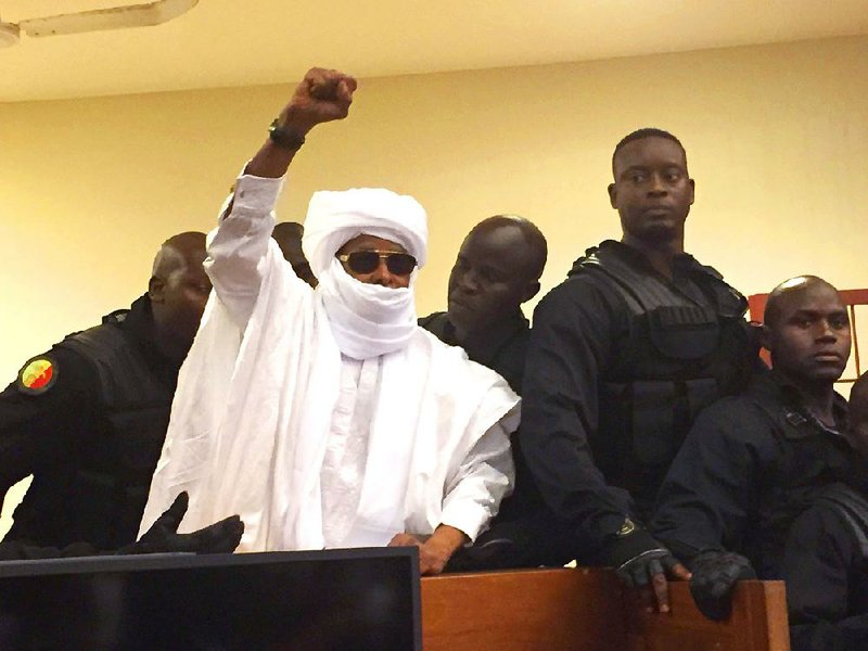Hissene Habre, Chad’s president from 1982-90, raises his fist Monday in Dakar, Senegal, during a hearing at which a special court sentenced him to life in prison for crimes committed during his time in power.