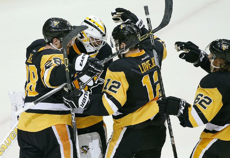 Pittsburgh goalie Matt Murray (center) is surrounded by teammates after stopping 24 shots to help the Penguins beat San Jose 3-2 in Game 1 of the Stanley Cup Final on Monday in Pittsburgh.