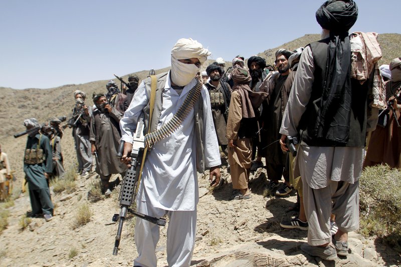 In this Friday, May 27, 2016 photo, members of a breakaway faction of the Taliban fighters walks during a gathering, in Shindand district of Herat province, Afghanistan. Mullah Abdul Manan Niazi said Sunday, May 29, 2016 he was willing to hold peace talks with the Afghan government but would demand the imposition of Islamic law and the departure of all foreign forces. (AP Photo/Allauddin Khan)