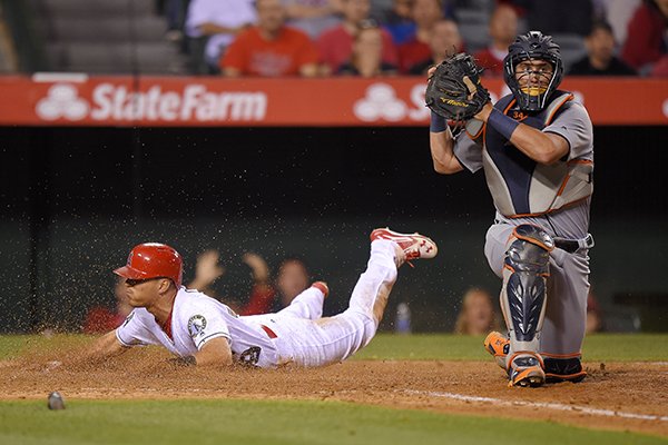 Los Angeles Angels' Rafael Ortega, left, slides in safe at home on a fielder's choice hit by Gregorio Petit as Detroit Tigers catcher James McCann throws to first during the eighth inning of a baseball game, Monday, May 30, 2016, in Anaheim, Calif. (AP Photo/Mark J. Terrill)