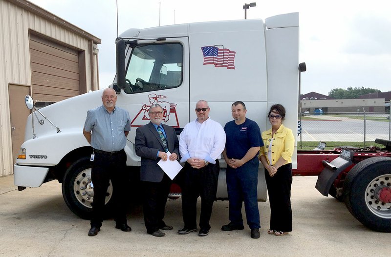 Submitted Photo Standing next to the diesel tractor given to the Gentry School District for its diesel mechanics&#8217; training by McKee Foods on Thursday was James Berry, McKee Foods Gentry fleet maintenance superintendent (left); Randy Barrett, superintendent of Gentry Public Schools; John Williams, McKee Foods Transportation corporate fleet maintenance manager from Collegedale, Tenn.; Tyson Sontag, McKee Foods diesel technician and Gentry High School Conversion Charter diesel instructor; and Judy Winslett, assistant superintendent of Gentry Public Schools.