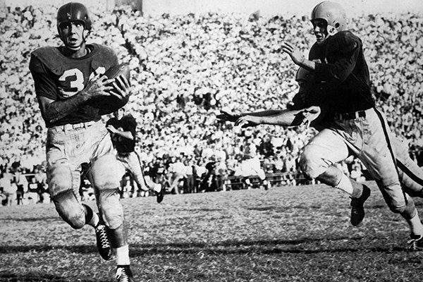 University of Arkansas football player Preston Carpenter, left, outruns Ole Miss players as he heads for the end zone to score giving Arkansas the 6-0 win at War Memorial Stadium in Little Rock, Ark., on Oct. 23, 1954. The game was played before the stadium's first overflow crowd of 38,000, and began the modern era of fan dedication to the Razorbacks. (AP Photo/Arkansas Democrat-Gazette, File)