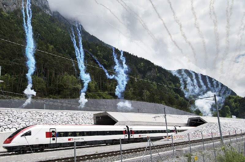The first train to exit the Gotthard rail tunnel’s north portal near Erstfeld, Switzerland, is greeted with a fi reworks display Wednesday. 
