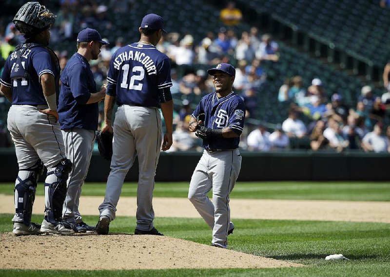 San Diego Padres shortstop Alexi Amarista (right) arrives at the mound to relieve Christian Bethancourt during Tuesday’s 16-4 loss to the Seattle Mariners. Bethancourt, a catcher, had a pitch register 96 mph in his first mound appearance since before high school.