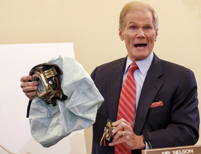 In this Nov. 20, 2014, file photo, Senate Commerce Committee member Sen. Bill Nelson, D-Fla., holds an example of a defective air bag made by Takata of Japan that has been linked to multiple deaths and injuries in cars driven in the U.S., during a hearing on Capitol Hill in Washington. 