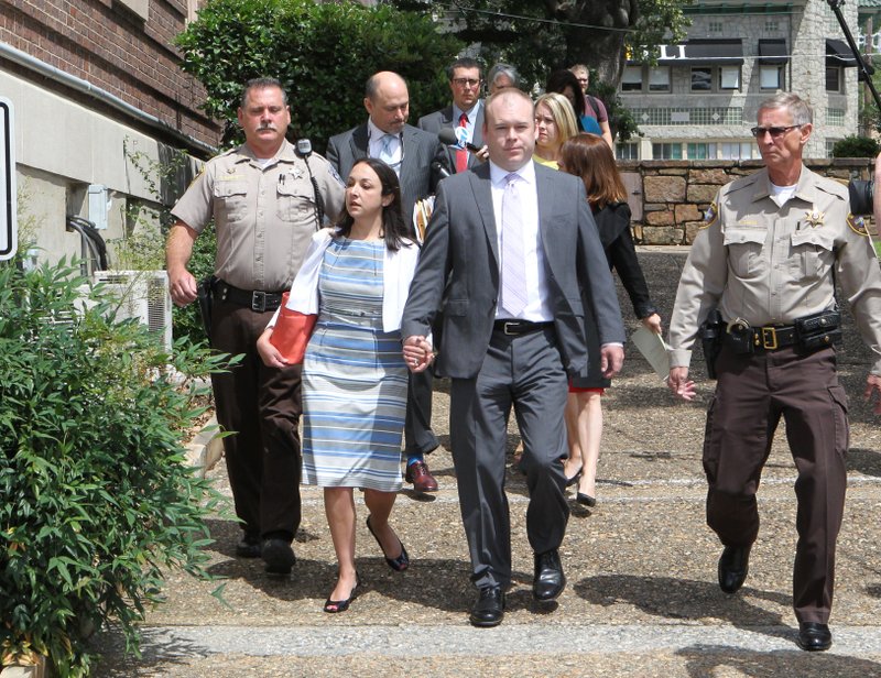 Judge Wade Naramore, center, and his wife, Ashley Naramore, are escorted around the Garland County Courthouse after a pretrial hearing Friday, June 3, 2016. (The Sentinel-Record/Richard Rasmussen)