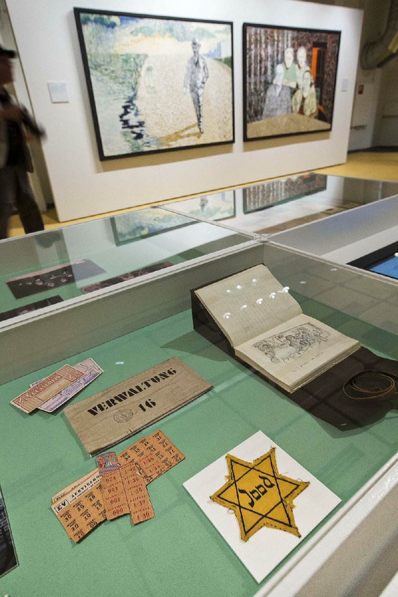 The Jewish star badge worn by the grandmother of Dutch actor and artist Jeroen Krabbe is displayed along with other items and some of Krabbe’s paintings at the National Holocaust Museum in Amsterdam. 