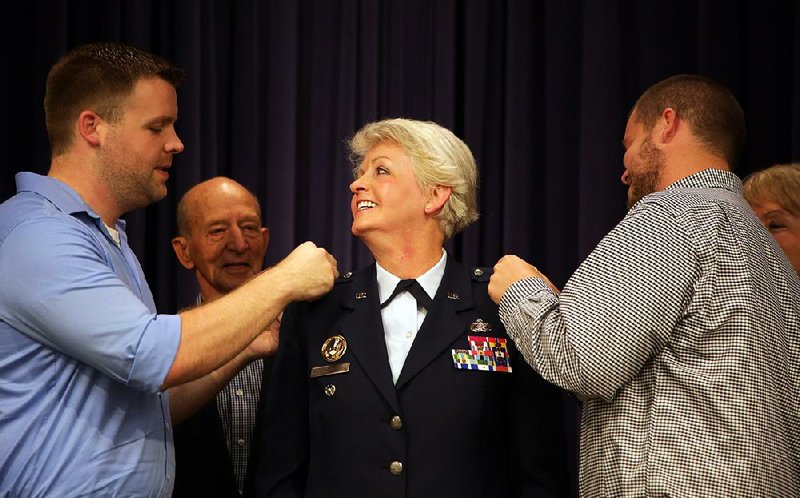 New Brig. Gen. Tamhra Hutchins-Frye smiles as her sons Trey (left) and Tyler Gray pin on her stars during her promotion ceremony Saturday at Camp Robinson in North Little Rock. Hutchins-Frye is the first woman to be promoted to general in the history of the Arkansas Air National Guard. 