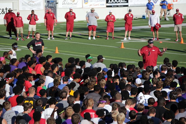 Arkansas coach Bret Bielema, right, talks to players as Arkansas State coach Blake Anderson, left, looks on during the All Arkansas satellite camp Sunday, June 5, 2016, at War Memorial Stadium in Little Rock.