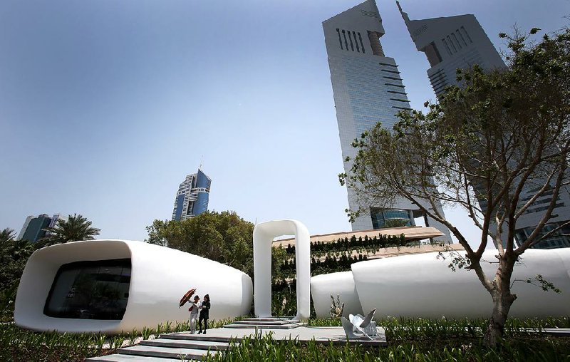 Two women in Dubai pass what the United Arab Emirates says is the world’s first functional office building made using three-dimensional printer technology.