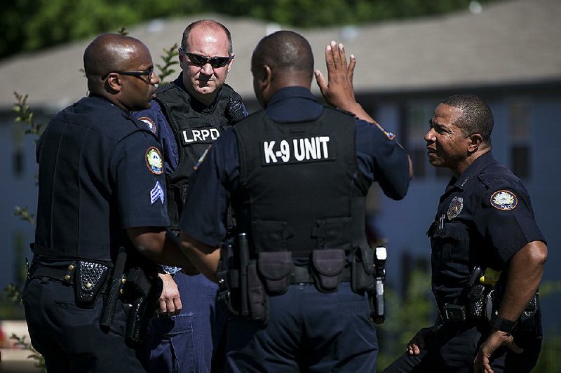 Little Rock police officers investigate a shooting Monday at the Arkansas River Apartments at 6900 Cantrell Road. One man was killed and two people, including a toddler, were injured in the shooting.