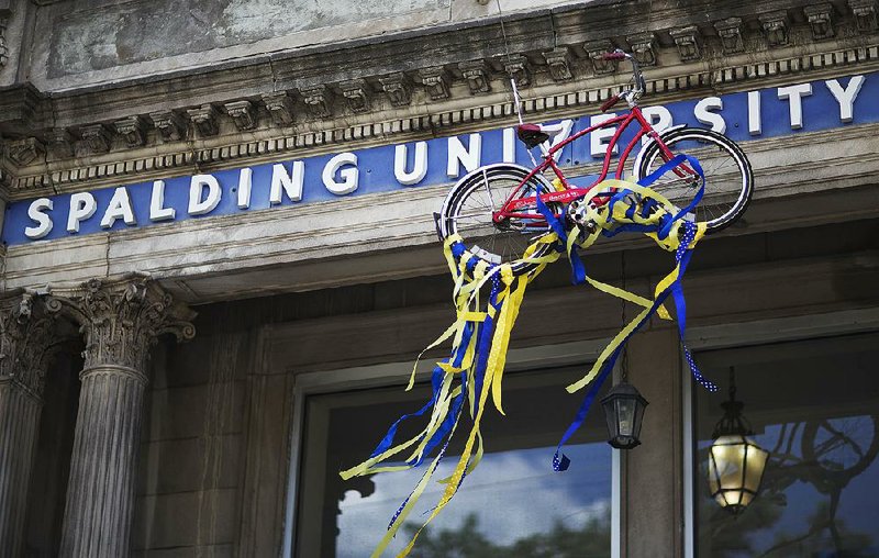 A red bicycle hangs from Spalding University in Louisville, Ky., in honor of Muhammad Ali, who had his red bicycle stolen at the age of 12. Ali took up boxing and vowed to whip the culprit who stole his bicycle. 