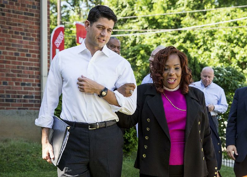 House Speaker Paul Ryan walks Tuesday with Bishop Shirley Holloway, director of the group House of Help City of Hope in Anacostia, one of Washington’s poorest neighborhoods.