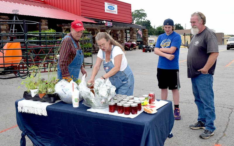 Photo by Mike Eckels

Diana Jordon (center) shows off shows LaVoyd McCutcheon (left), Austin Prine, and Jack Prine some of her jelly products during the opening of the Decatur Farmers Market in the parking area of the Farmers Coop/True Value hardware store in downtown Decatur June 2.