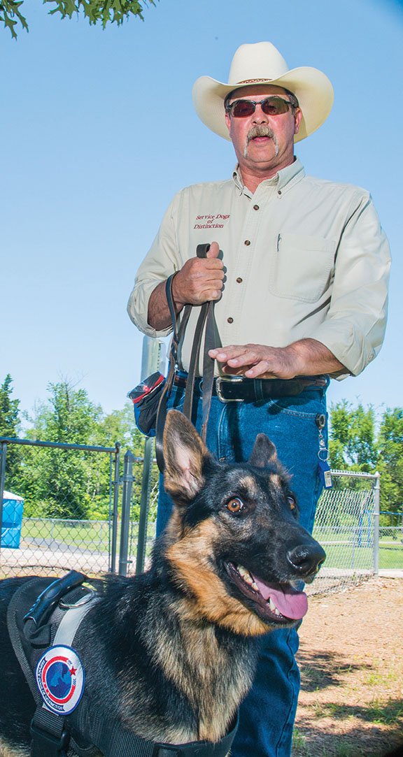 Don Gardner, Service Dogs of Distinction president and head trainer, sits with Elsa, a donated German shepherd who is being trained to be a service dog for veterans with post-traumatic stress disorder or traumatic brain injuries.
