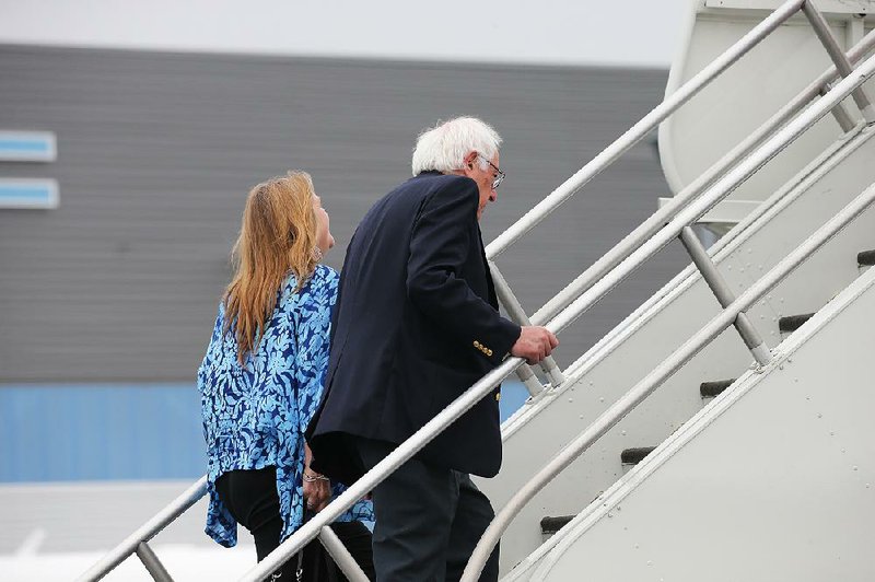 Bernie Sanders and his wife, Jane, board a plane Wednesday in Los Angeles to fly home to Vermont. Sanders, who has vowed to continue his campaign, is to meet with President Barack Obama today. 