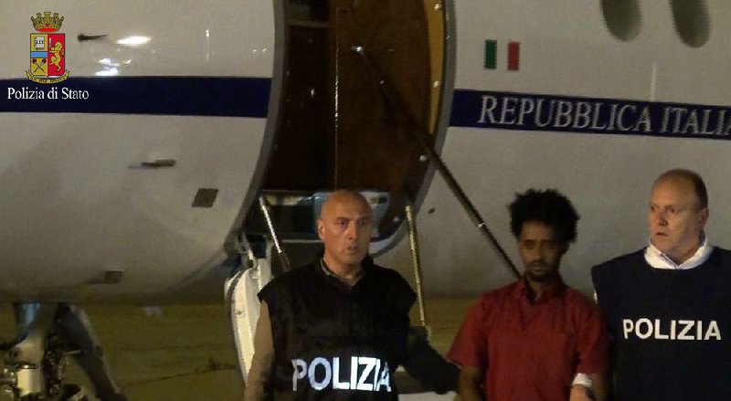 This photo taken from a video and released by the Italian police shows Medhane Yehdego Mered, sn Eritrean who was arrested two weeks ago in Sudan, upon his arrival late Tuesday at Ciampino Airport on the outskirts of Rome. 