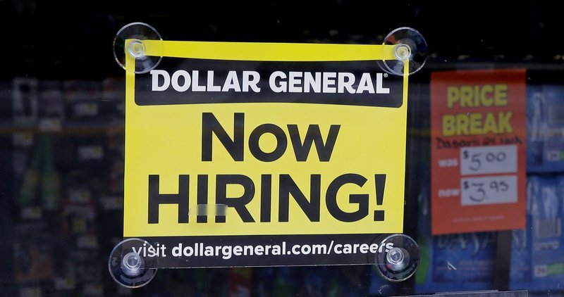 In this Wednesday, May 18, 2016, photo, a "Now Hiring" sign hangs in the window of a Dollar General store in Methuen, Mass.
