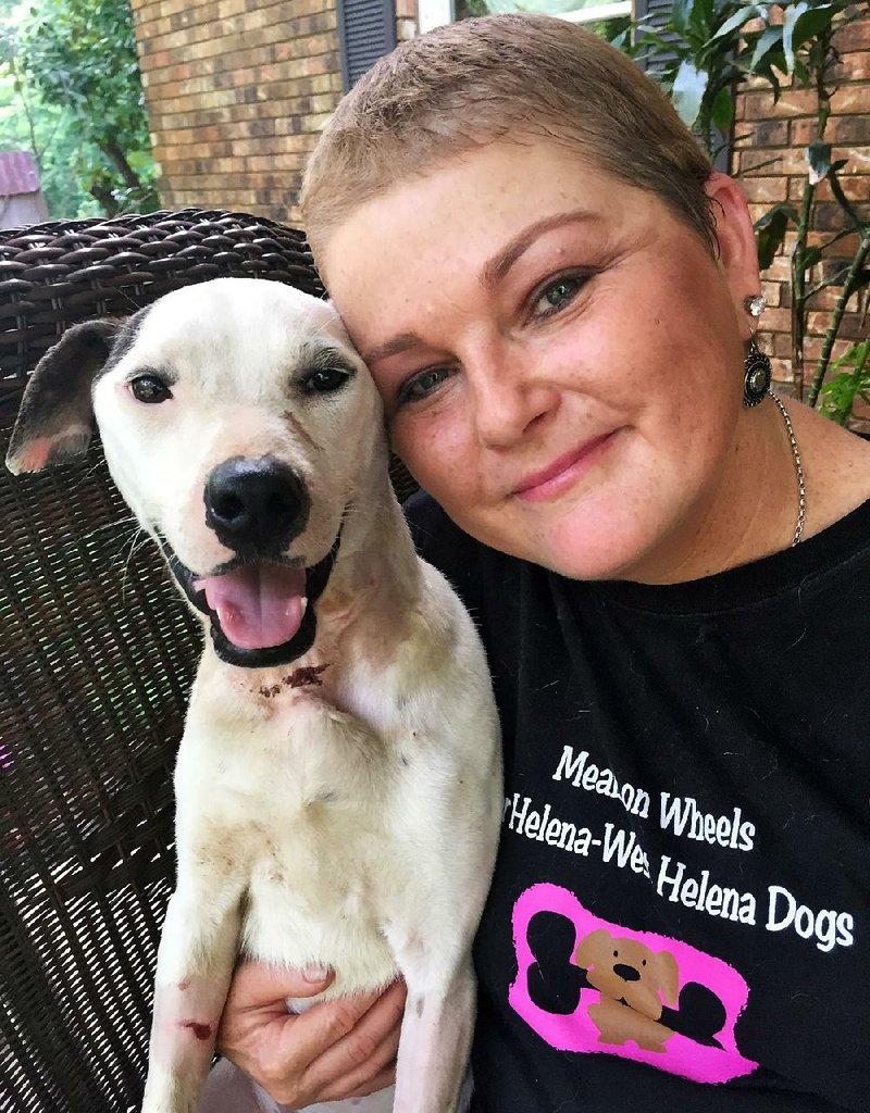 Leslie Galloway with her foster dog, Sky. The pooch was found dangling from a porch by an extension cord. Sky is recovering from malnourishment, heartworms and severe neck injuries, but she still trusts and loves people.