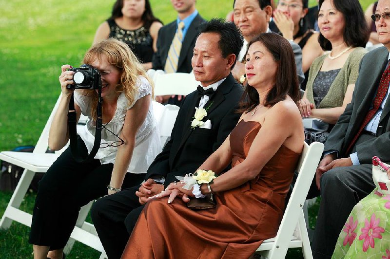 Wedding photographer Andi Schreiber (left) documents the wedding ceremony of Jennifer Chen and Tony Tran at Wainwright House in Rye, N.Y., in June 2010. Photographers advise the betrothed to think about booking a photographer soon after selecting the venue, and make sure he is a good fit with your personality. 
