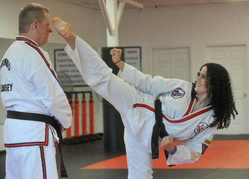 Cheyanne Burrous, 17, of Siloam Springs practices her taekwondo Thursday with master Jerry Lindsey from Impact Martial Arts in Springdale as she prepares for competition in Europe.