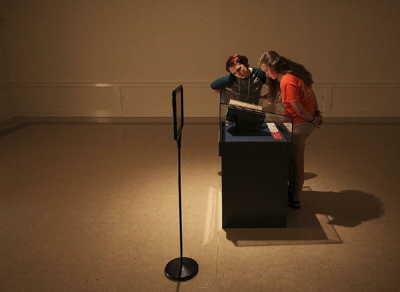 Madison Stark (left), 18, and Hayley Harp, 20, view on Thursday the First Folio, a 1623 compilation of plays by William Shakespeare on display at the University of Central Arkansas in Conway. 