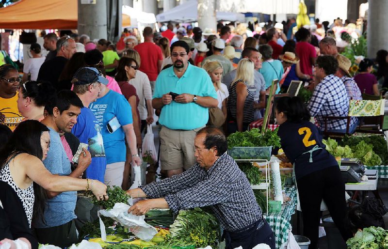 Visitors buy goods Saturday at the Little Rock Farmers Market, which participates in a program that allows food-stamp recipients access to more fresh produce. 