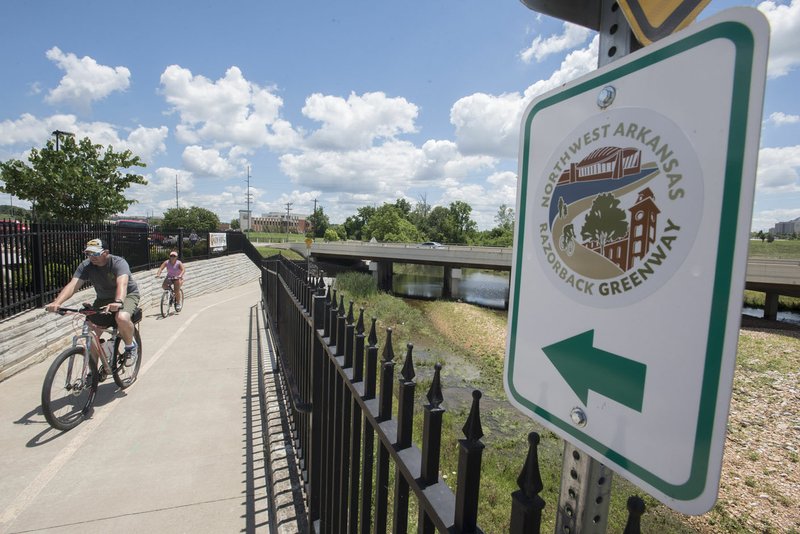 NWA Democrat-Gazette/J.T. WAMPLER Cyclists navigate a trail near the Razorback Greenway trail in Rogers.