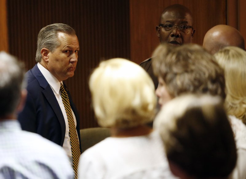 Mike Hubbard looks at family and friends sitting in the courtroom Friday as deputies wait to take Hubbard into custody in Opelika, Ala.