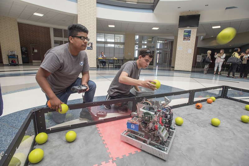 Santiago Saucedo (left) and Aaron Layman show their ball launching robot named Adam during the 2016 Innovation Institute Wednesday at Har-Ber High School. Educators attending the institute examined how to transform technology practices to support teaching and learning.